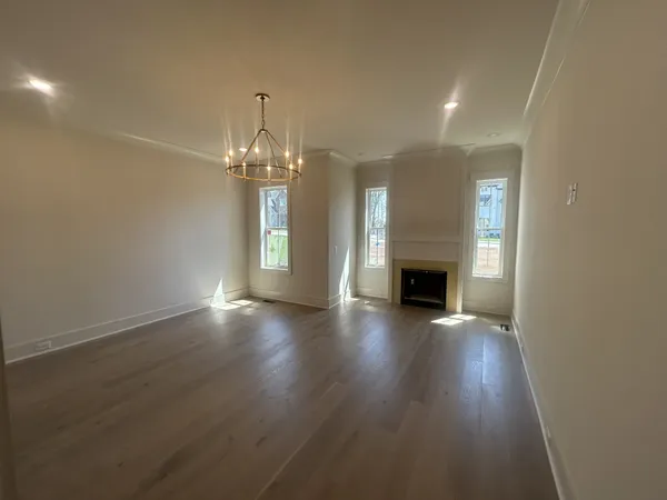 an empty room with wooden floor and fireplace