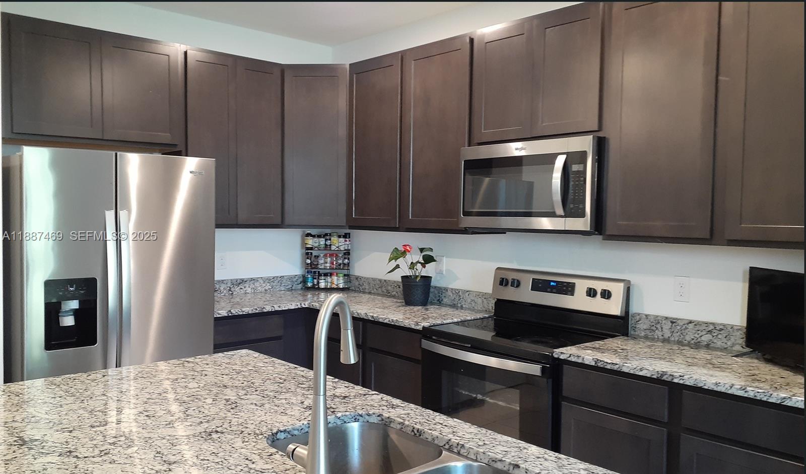 3575 Northwest 1st Street Pompano Beach, FL 33069 - Photo 4 of 18 a kitchen with stainless steel appliances granite countertop a refrigerator stove and microwave