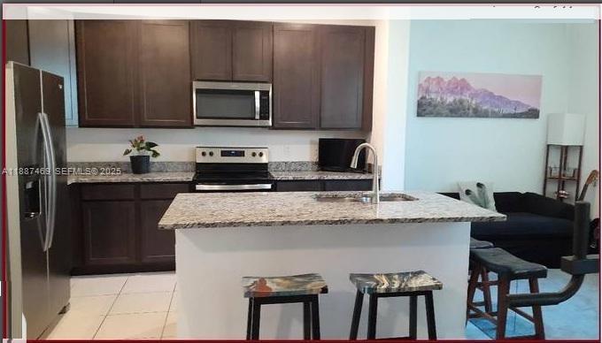 3575 Northwest 1st Street Pompano Beach, FL 33069 - Photo 5 of 18 a kitchen with stainless steel appliances granite countertop a stove a sink and a microwave