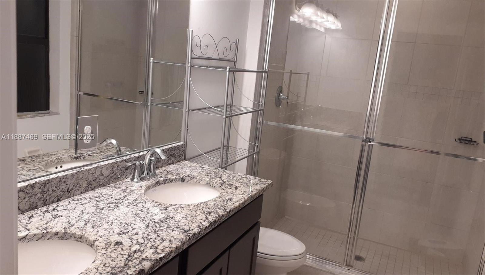 3575 Northwest 1st Street Pompano Beach, FL 33069 - Photo 7 of 18 a bathroom with a granite countertop sink toilet and shower