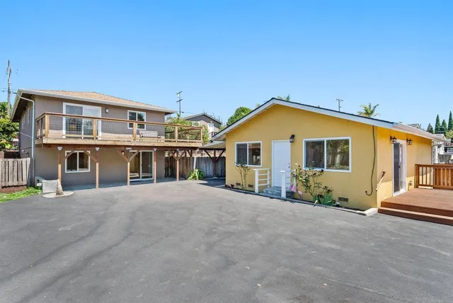 a view of house with a yard and balcony