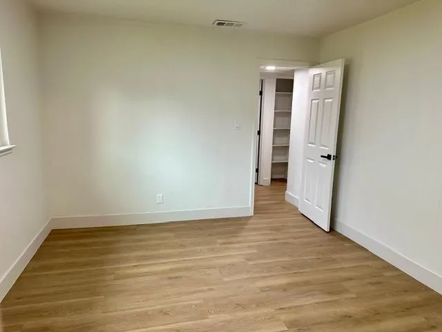 a view of a room with wooden floor and white walls