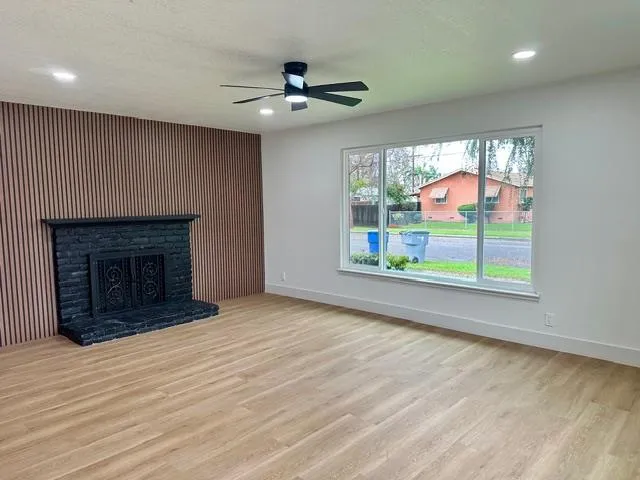 an empty room with windows and fireplace