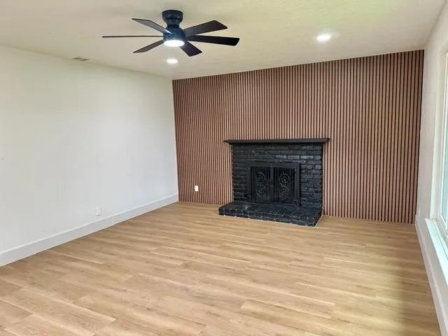 an empty room with fireplace and fan