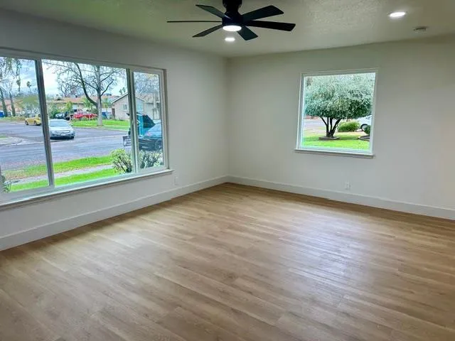 an empty room with wooden floor and windows