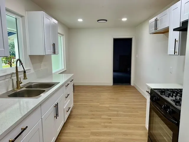 a kitchen with stainless steel appliances granite countertop a sink and a stove