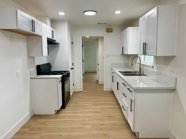 a kitchen with granite countertop a sink and a refrigerator