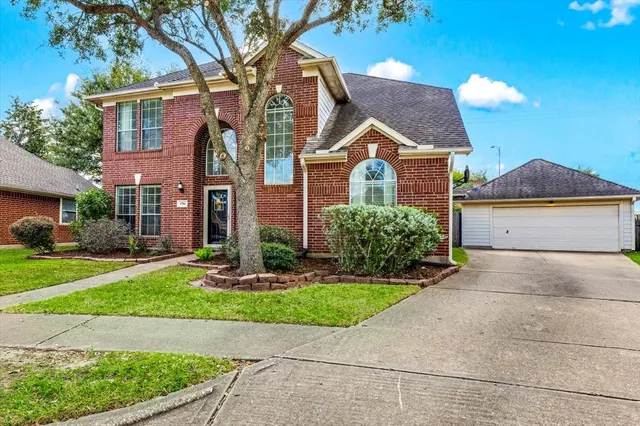 a front view of a house with a yard and potted plants