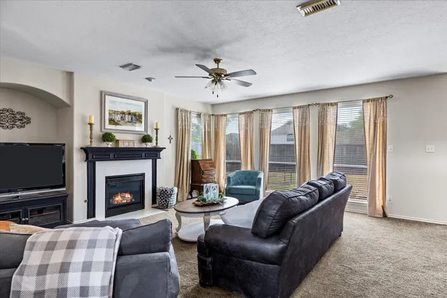 a living room with furniture a flat screen tv and a fireplace