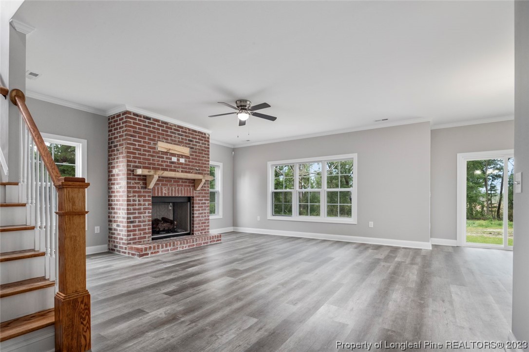 4750 Blue Sand Hill Road Fayetteville, NC 28312 - Photo 12 of 42 an empty room with windows fireplace and wooden floor