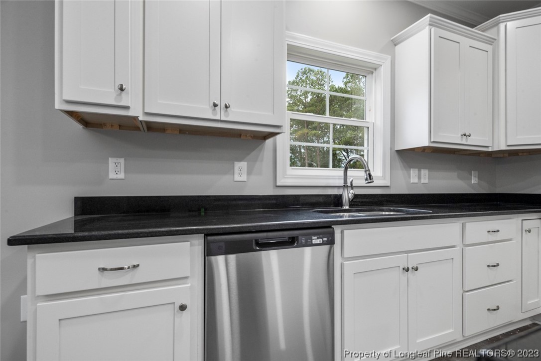 4750 Blue Sand Hill Road Fayetteville, NC 28312 - Photo 17 of 42 a kitchen with granite countertop white cabinets and a window