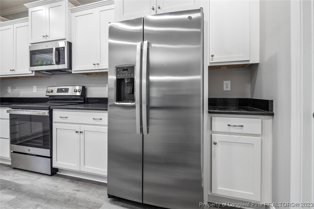 4750 Blue Sand Hill Road Fayetteville, NC 28312 - Photo 21 of 42 a kitchen with stainless steel appliances cabinets and a refrigerator