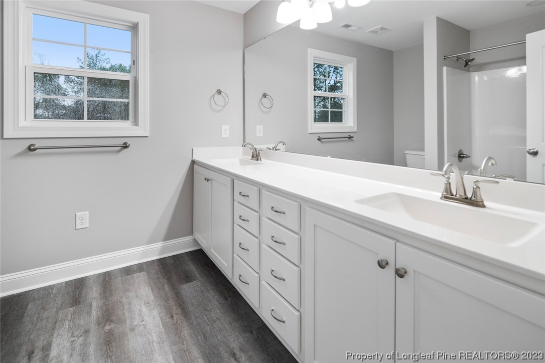 4750 Blue Sand Hill Road Fayetteville, NC 28312 - Photo 35 of 42 a spacious bathroom with double vanity sink a two mirror a window and a bathtub