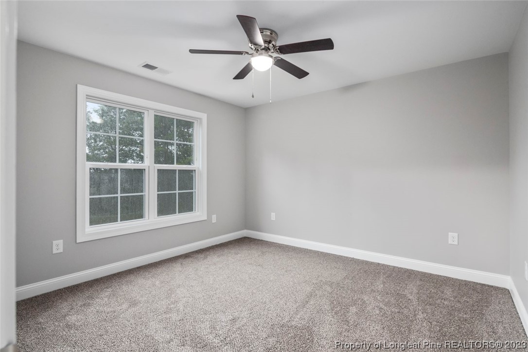 4750 Blue Sand Hill Road Fayetteville, NC 28312 - Photo 37 of 42 an empty room with a ceiling fan and windows