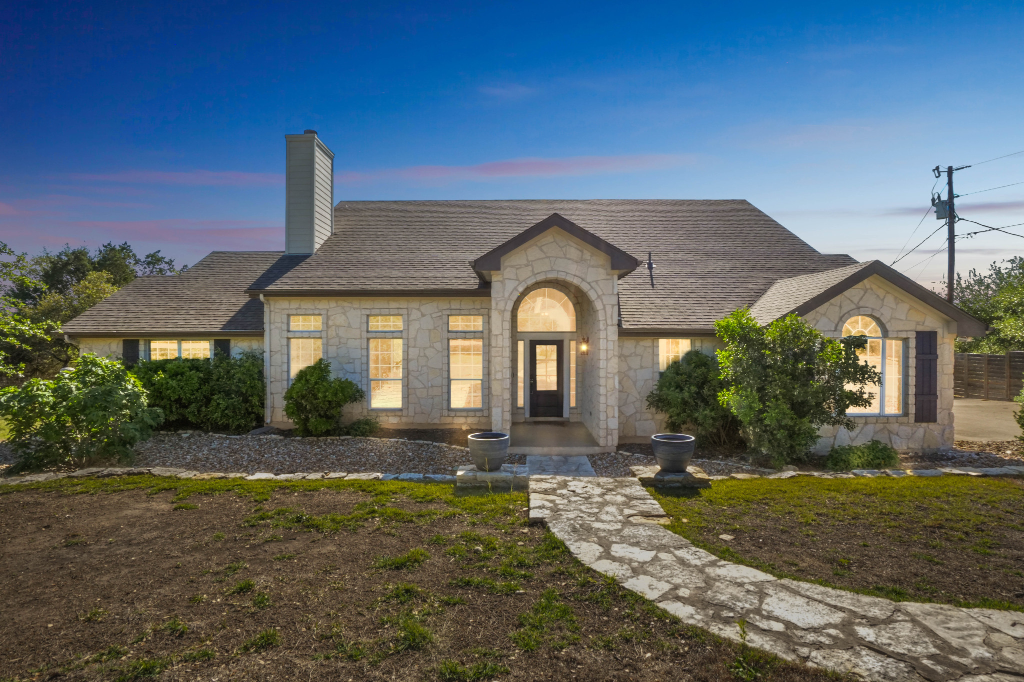 13624 Trautwein Road Austin, TX 78737 - Photo 1 of 38 A stone pathway leads to the welcoming arched entryway of this inviting property.