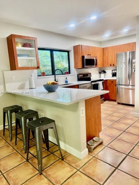 18163 Southwest 149th Place Miami, FL 33187 - Photo 37 of 49 a kitchen with stainless steel appliances kitchen island granite countertop a stove a sink a microwave a dining table and chairs