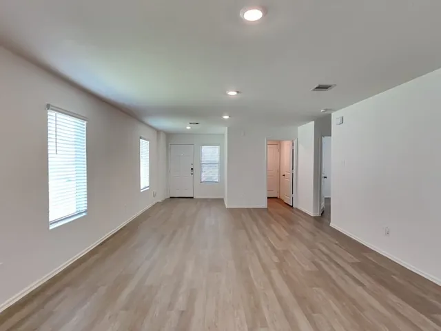 a view of a room with wooden floor and window