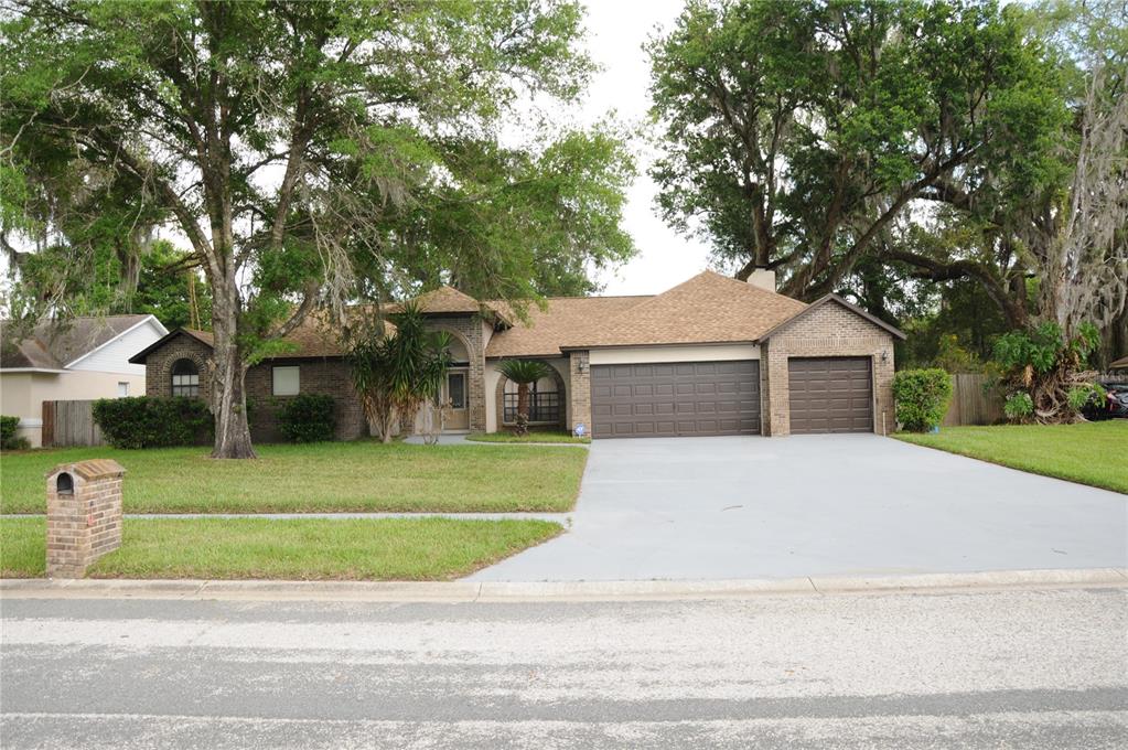 a front view of a house with a garden and trees