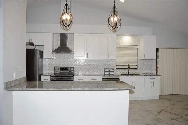 a kitchen with granite countertop a stove and a refrigerator