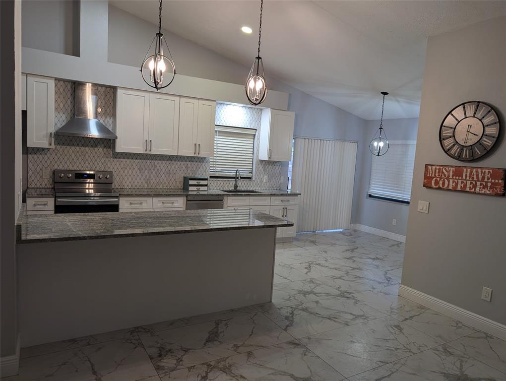 2106 Whitlock Place Dover, FL 33527 - Photo 16 of 83 a kitchen with stainless steel appliances granite countertop a sink a refrigerator and a stove