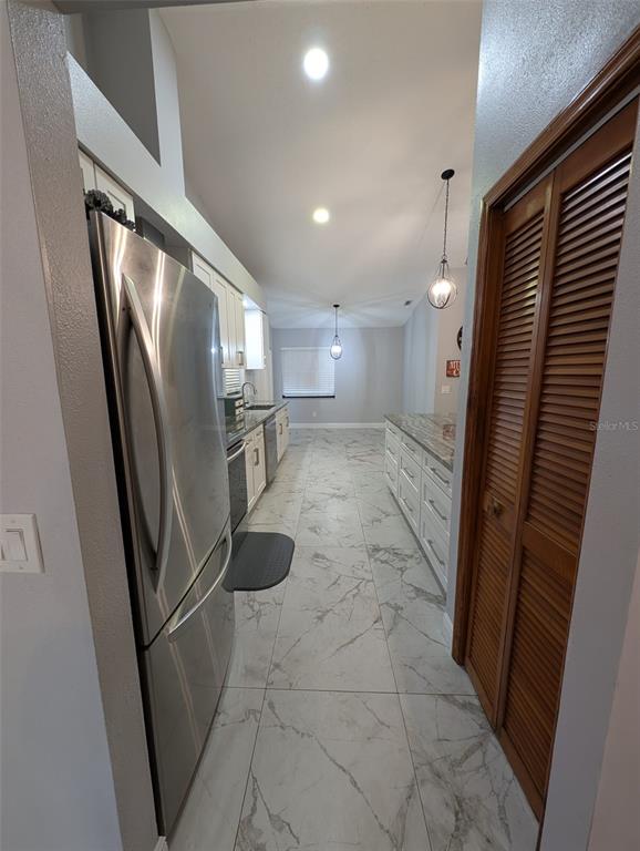 2106 Whitlock Place Dover, FL 33527 - Photo 21 of 83 a view of a refrigerator in kitchen and an empty room