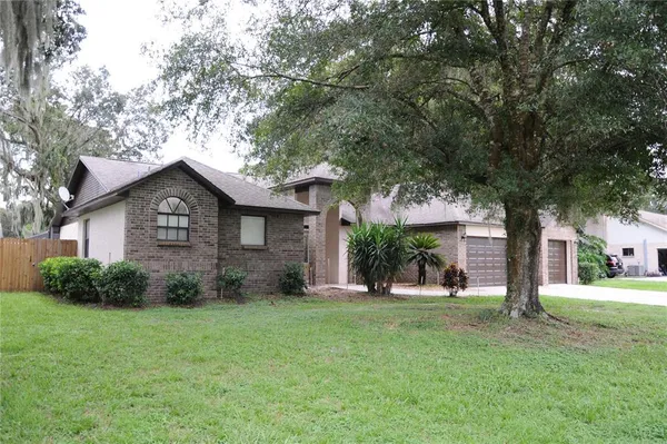 a brick house with trees in front of it