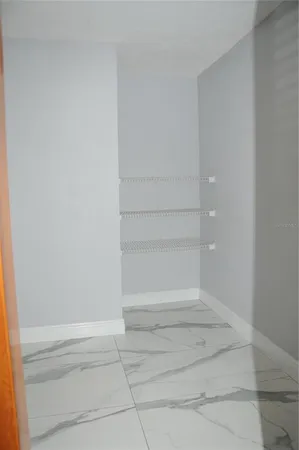 a view of a livingroom with a chandelier fan and closet