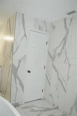 a bathroom with a granite countertop double vanity sink and mirror