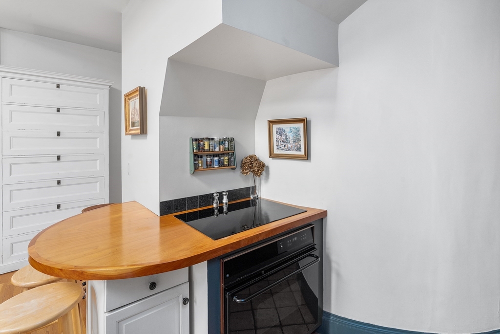 33 Hancock Street, Unit 4 Boston, MA 02114 - Photo 13 of 29 a kitchen with stainless steel appliances a sink and a stove with wooden floor
