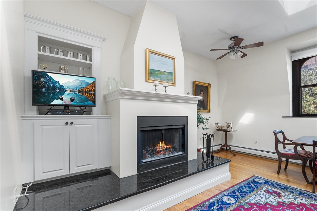 33 Hancock Street, Unit 4 Boston, MA 02114 - Photo 5 of 29 a living room with furniture a flat screen tv and a fireplace
