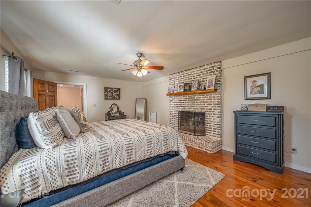 455 Sandy Plains Road Tryon, NC 28782 - Photo 14 of 28 a spacious bedroom with a bed and a fireplace
