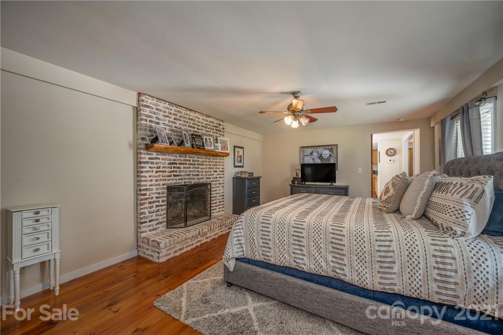 455 Sandy Plains Road Tryon, NC 28782 - Photo 15 of 28 a bedroom with a bed and a fireplace