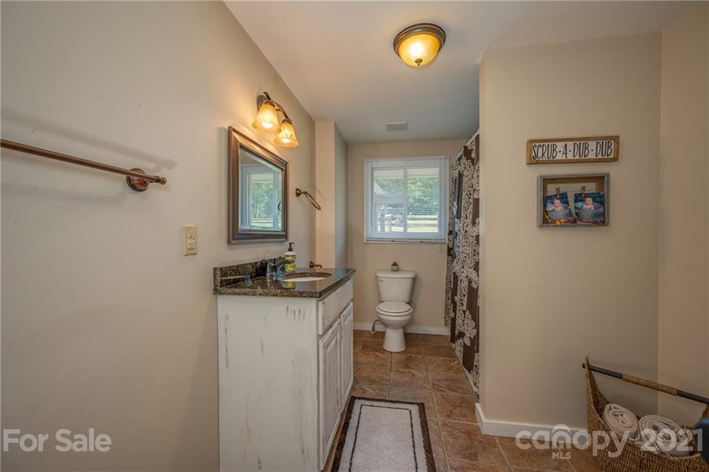 455 Sandy Plains Road Tryon, NC 28782 - Photo 18 of 28 a bathroom with a sink a toilet and a mirror