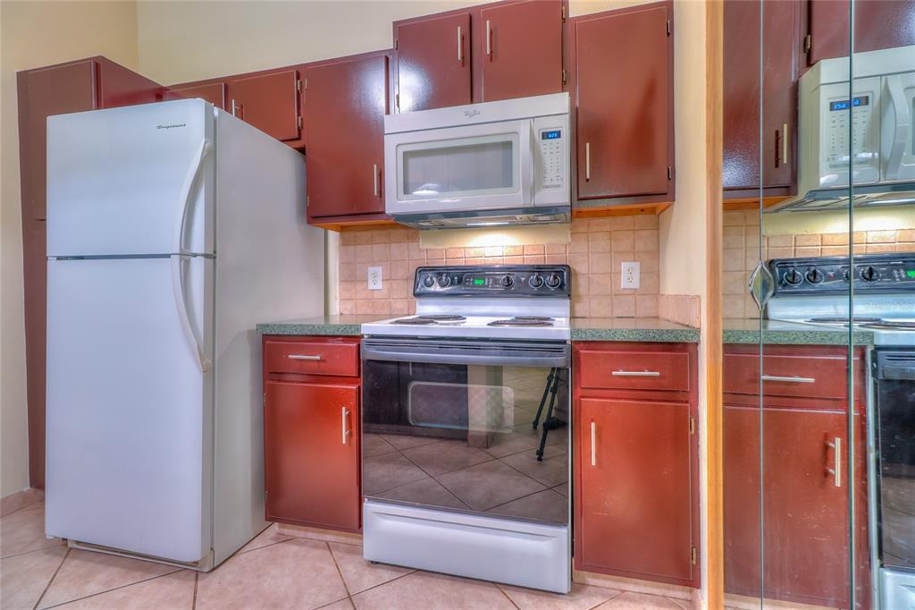 5100 Burchette Road, Unit 1607 Tampa, FL 33647 - Photo 18 of 39 a kitchen with stainless steel appliances granite countertop a refrigerator and a stove top oven
