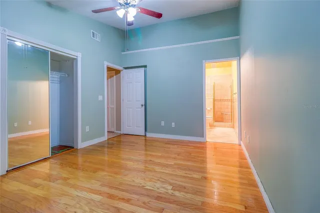 a view of an empty room with window and wooden floor