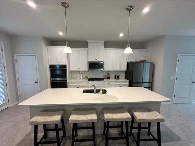 a kitchen with granite countertop a sink and a stove top oven with wooden floor
