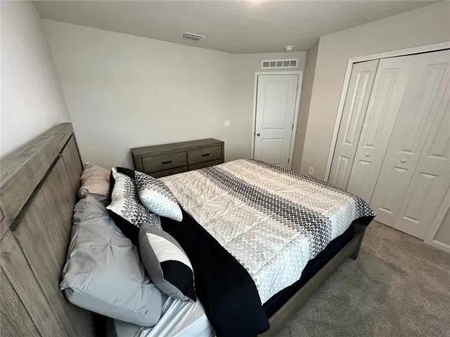 a bed sitting in a bedroom next to a window