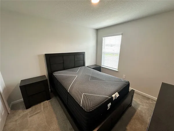 a bed sitting in a bedroom and wooden floor