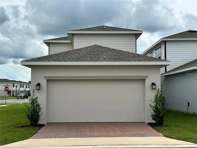 a front view of a house with a garden and garage