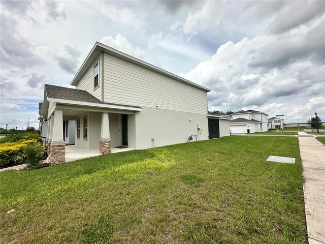a view of a house with a yard and sitting area