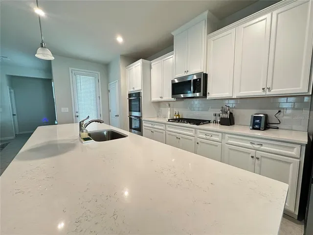 a kitchen with stainless steel appliances a refrigerator sink and microwave