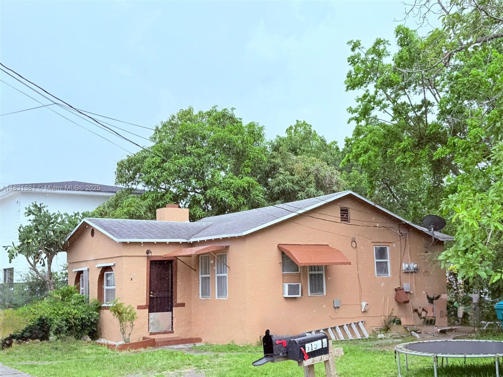 5158 Northwest 19th Avenue Miami, FL 33142 - Photo 2 of 2 a view of a yard in front of a house with plants and large tree