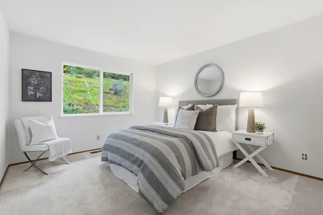 a bedroom with a bed chair and window