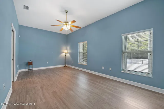 an empty room with closet and a chandelier fan