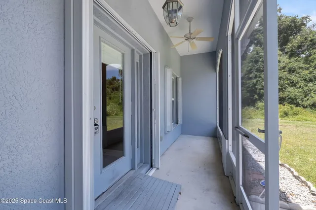 a view of a room with wooden floor and a ceiling fan