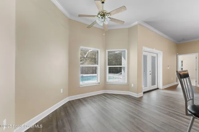 a view of a room with wooden floor and ceiling fan
