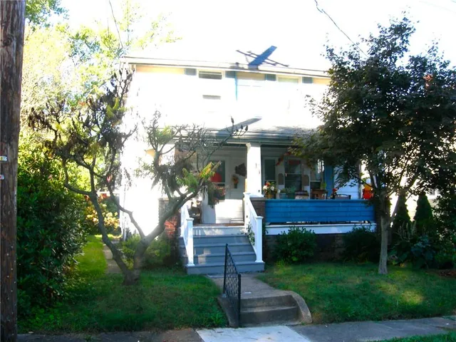 a view of house with a yard and sitting area