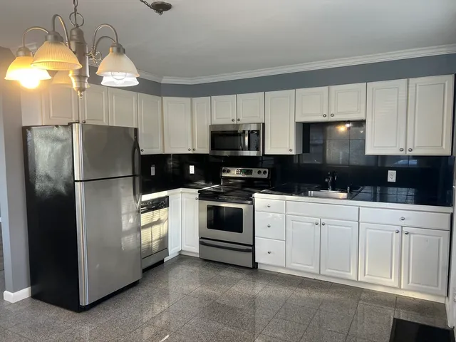 a kitchen with a refrigerator a stove a microwave and cabinets