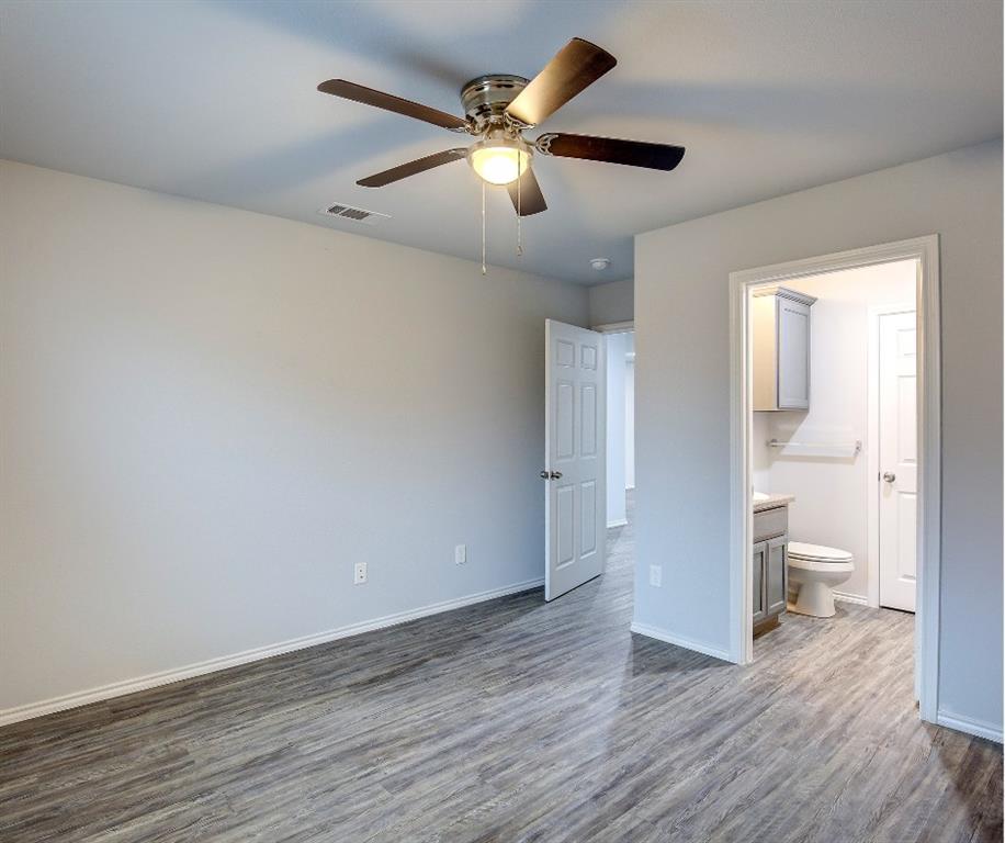 800 Sycamore Street Commerce, TX 75428 - Photo 5 of 8 an empty room and wooden floor and a ceiling fan
