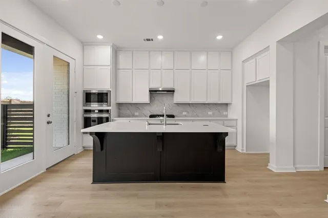 a kitchen with stainless steel appliances a sink stove and refrigerator